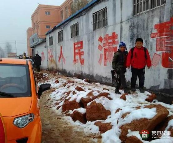 前去上學的孩子走在濕滑的道路上